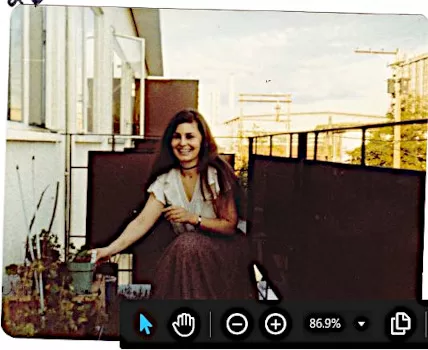 young chris smiling radiantly looking at camera while reaching out to plant growing on apartment balcony Vancouver BC Canada